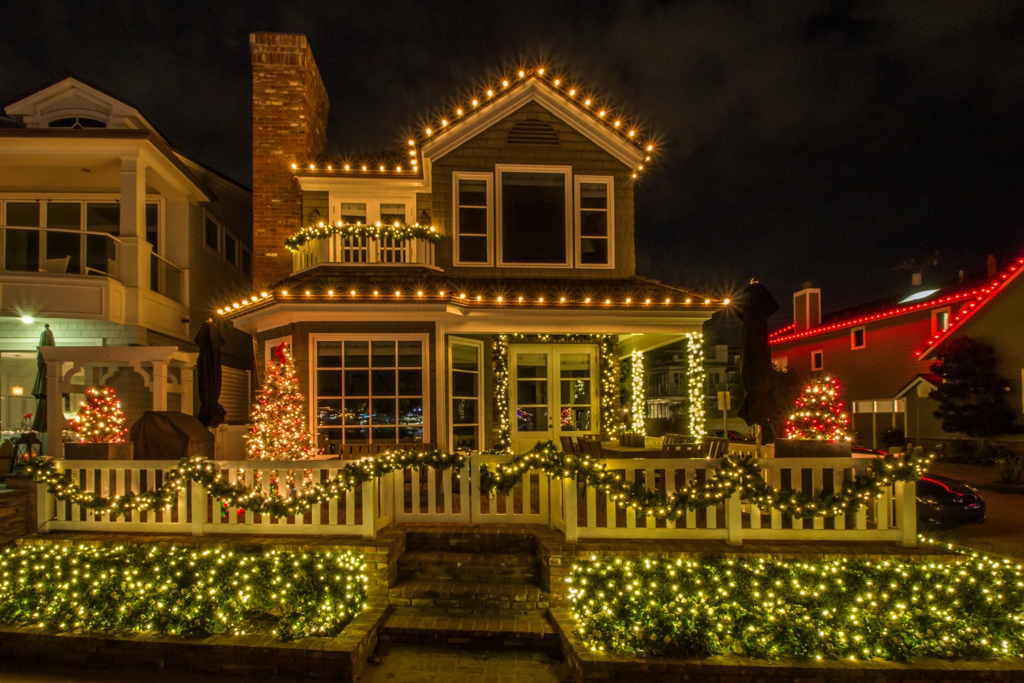 Elegant home with warm-white holiday roofline lighting at dusk