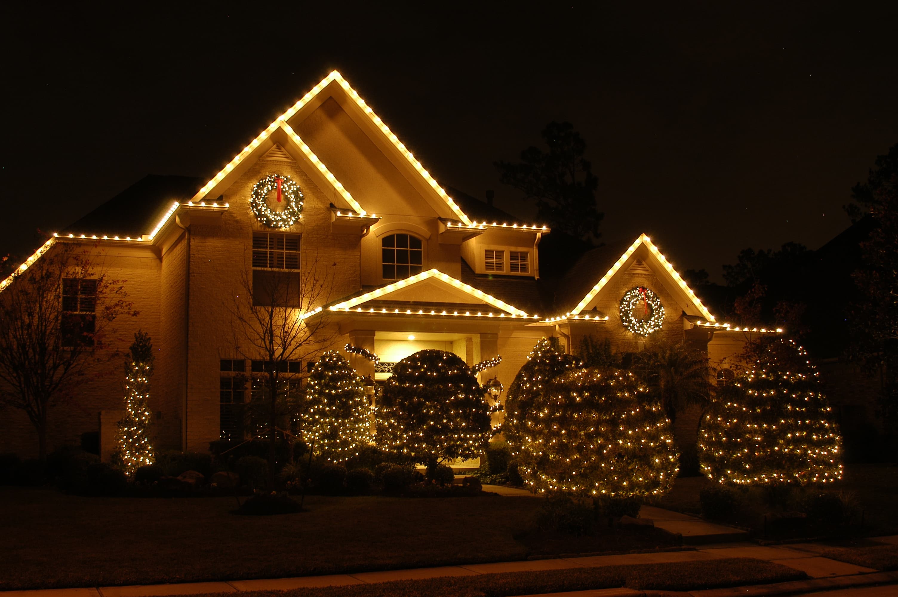 Roofline & entry garland — timeless holiday warmth.